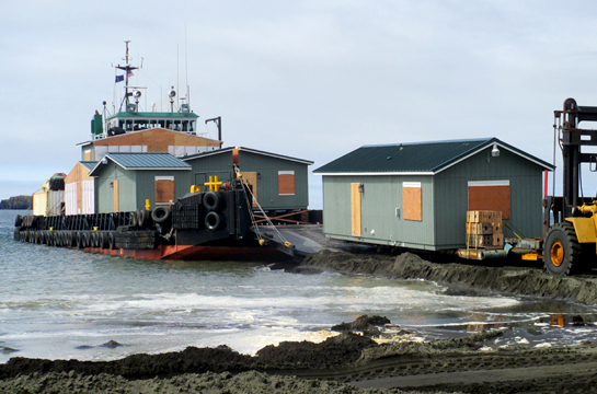 Modular prefab home being unloaded from a barge